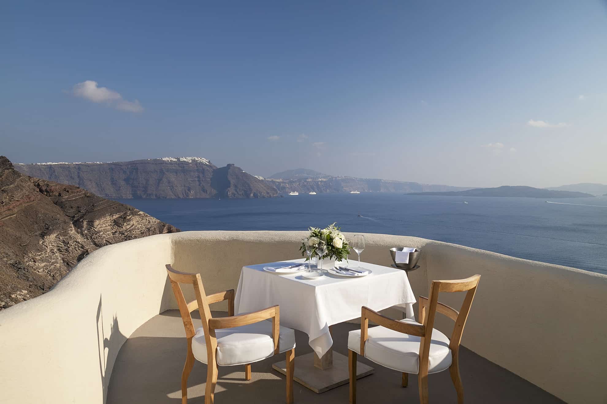 Patio en lo alto de colina con vista al mar y las montañas y una romántica mesa dispuesta para dos