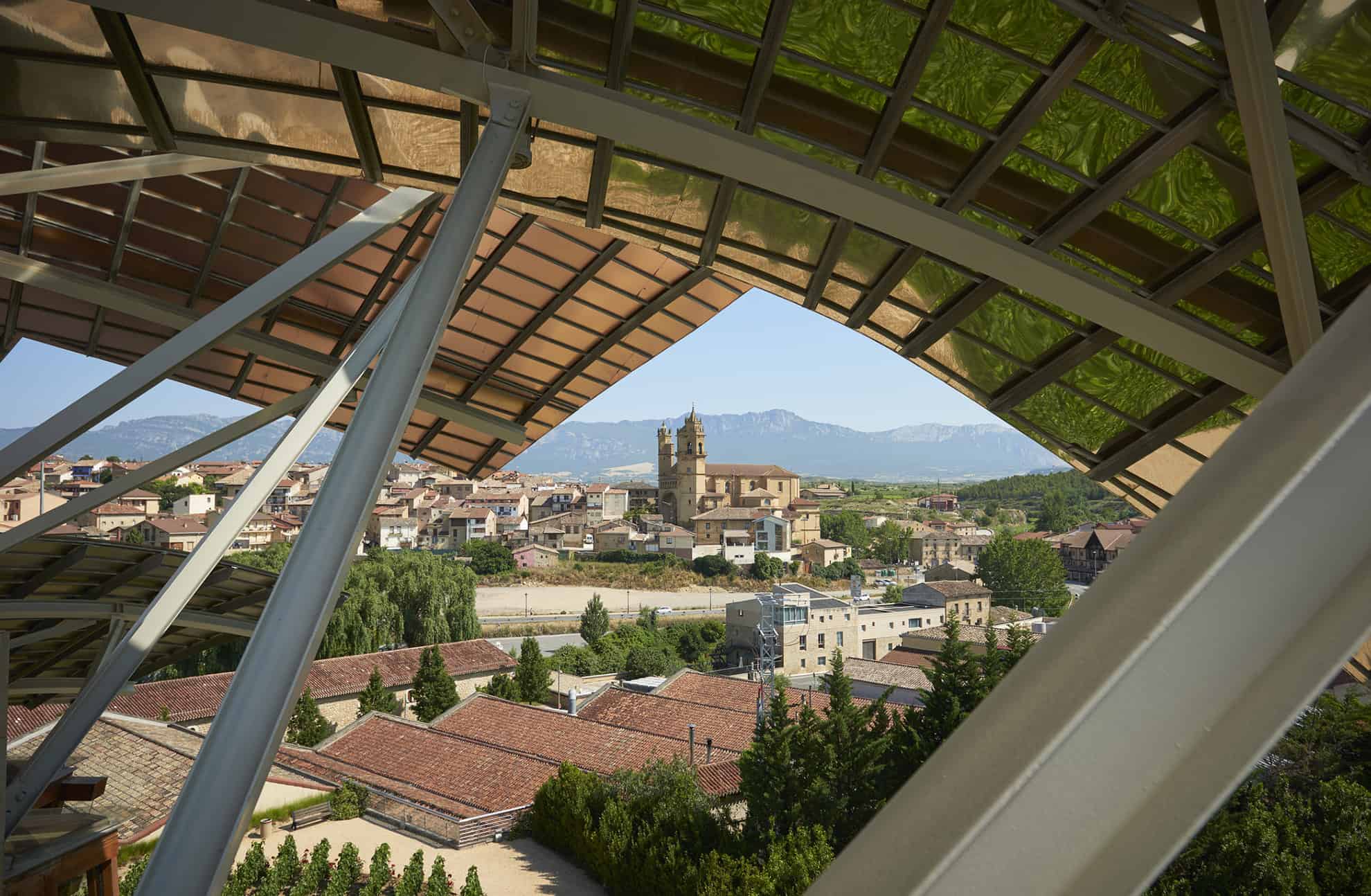 Blick von einem Balkon in der oberen Etage auf die spanische Stadt Elciego mit Bergen in der Ferne