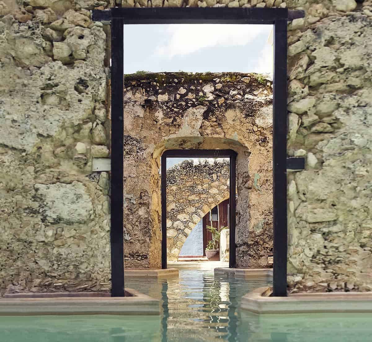 Outdoor freeform pool going through stone archways