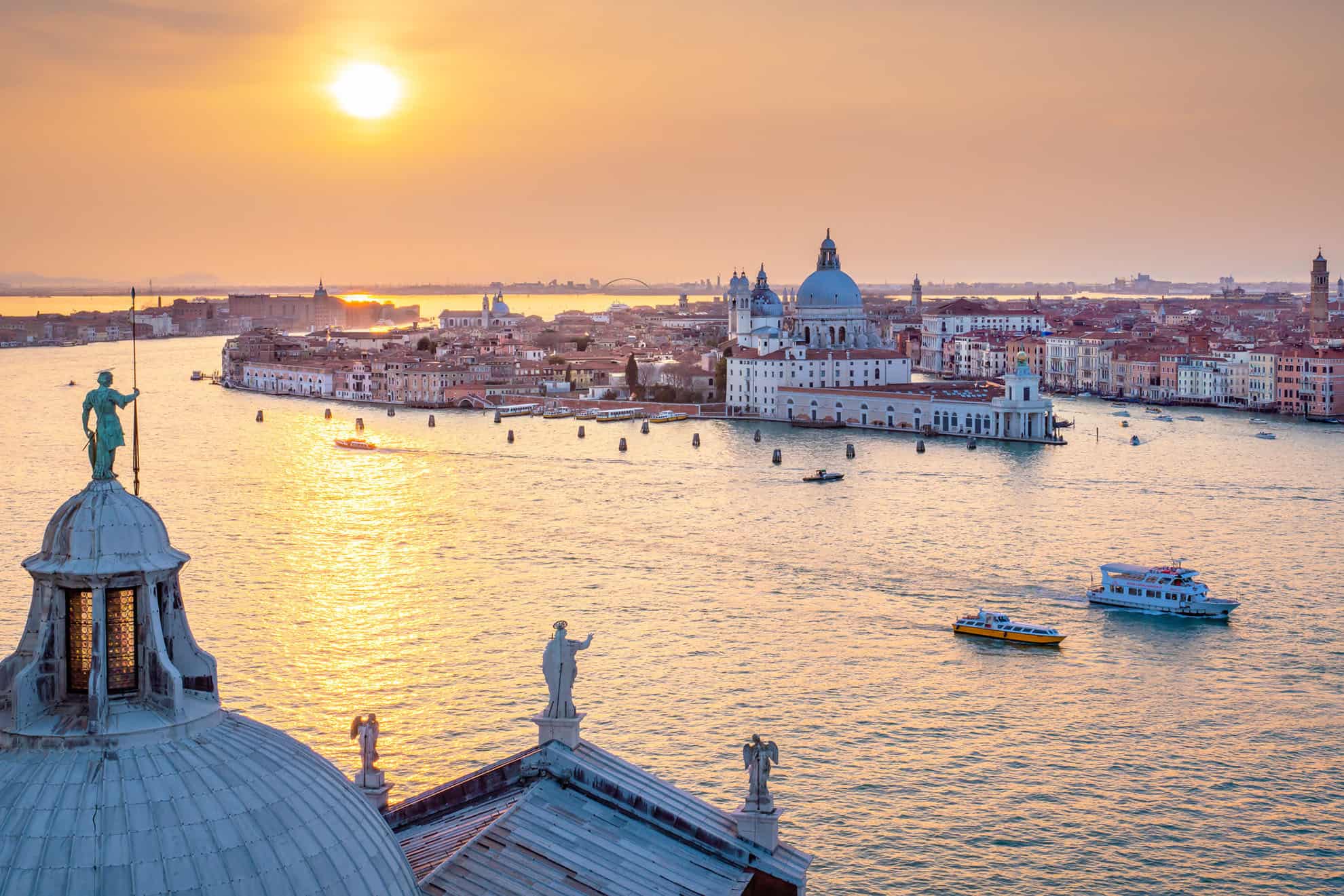 Aerial view of Venice cityscape and water's edge at sunset