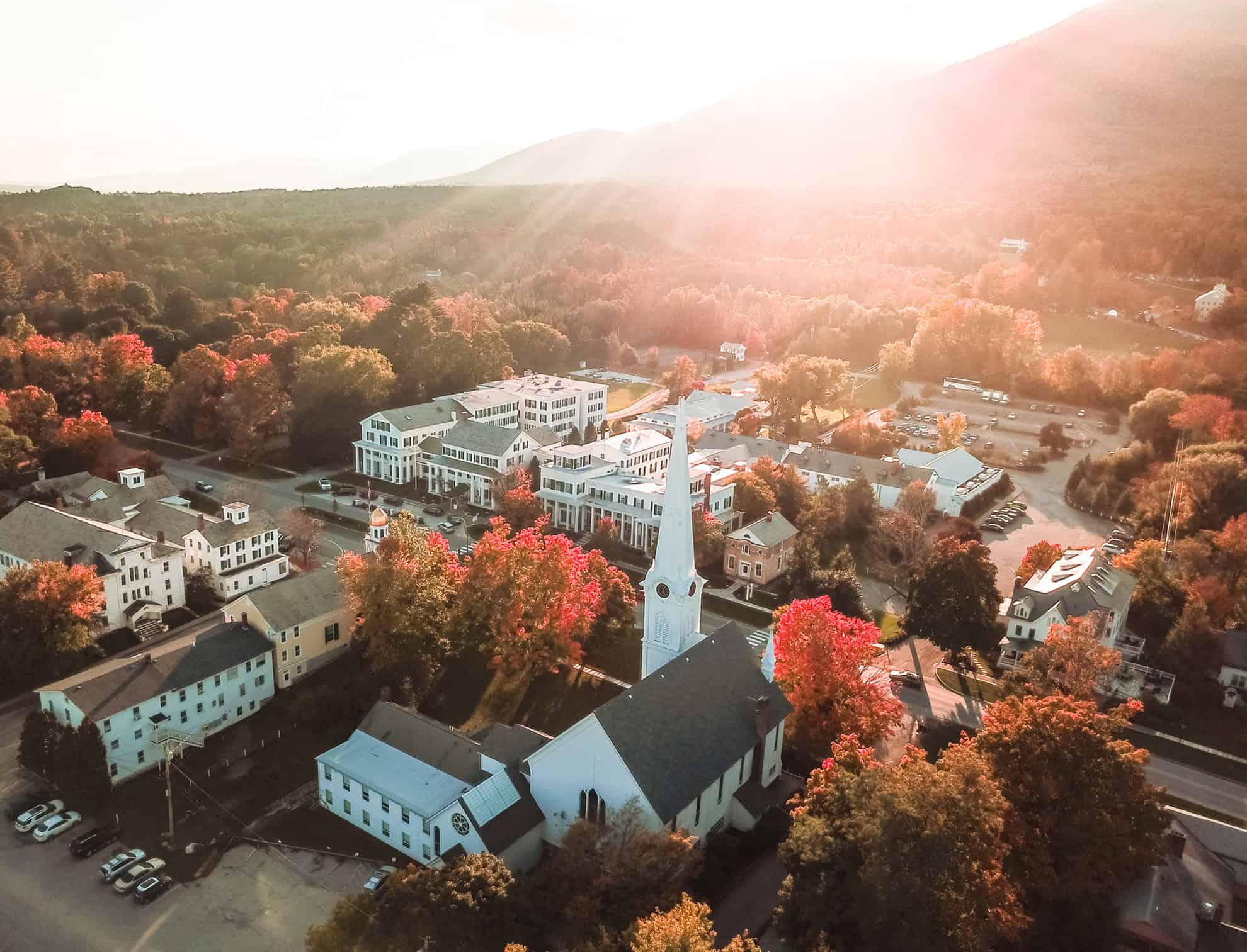 Aerial view of small town with white buildings surrounded by automn trees