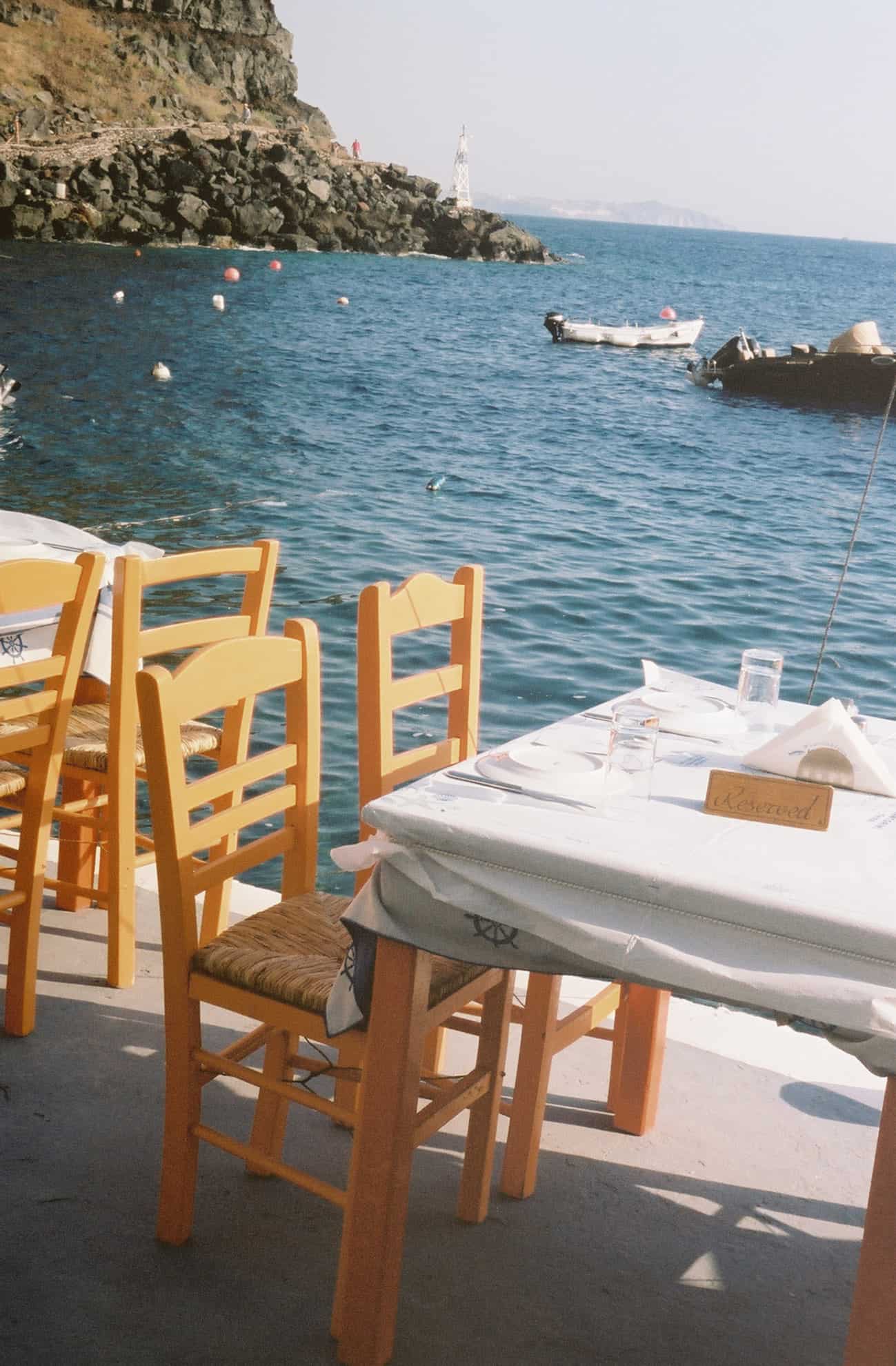 Oceanside dining with fishing boats tied off nearby; near cliffs