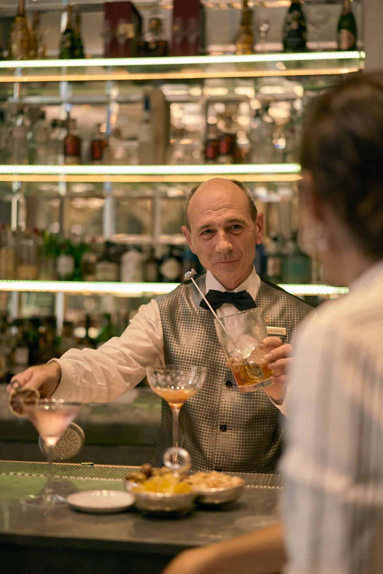 Bartender preparing a martini for a customer at the bar