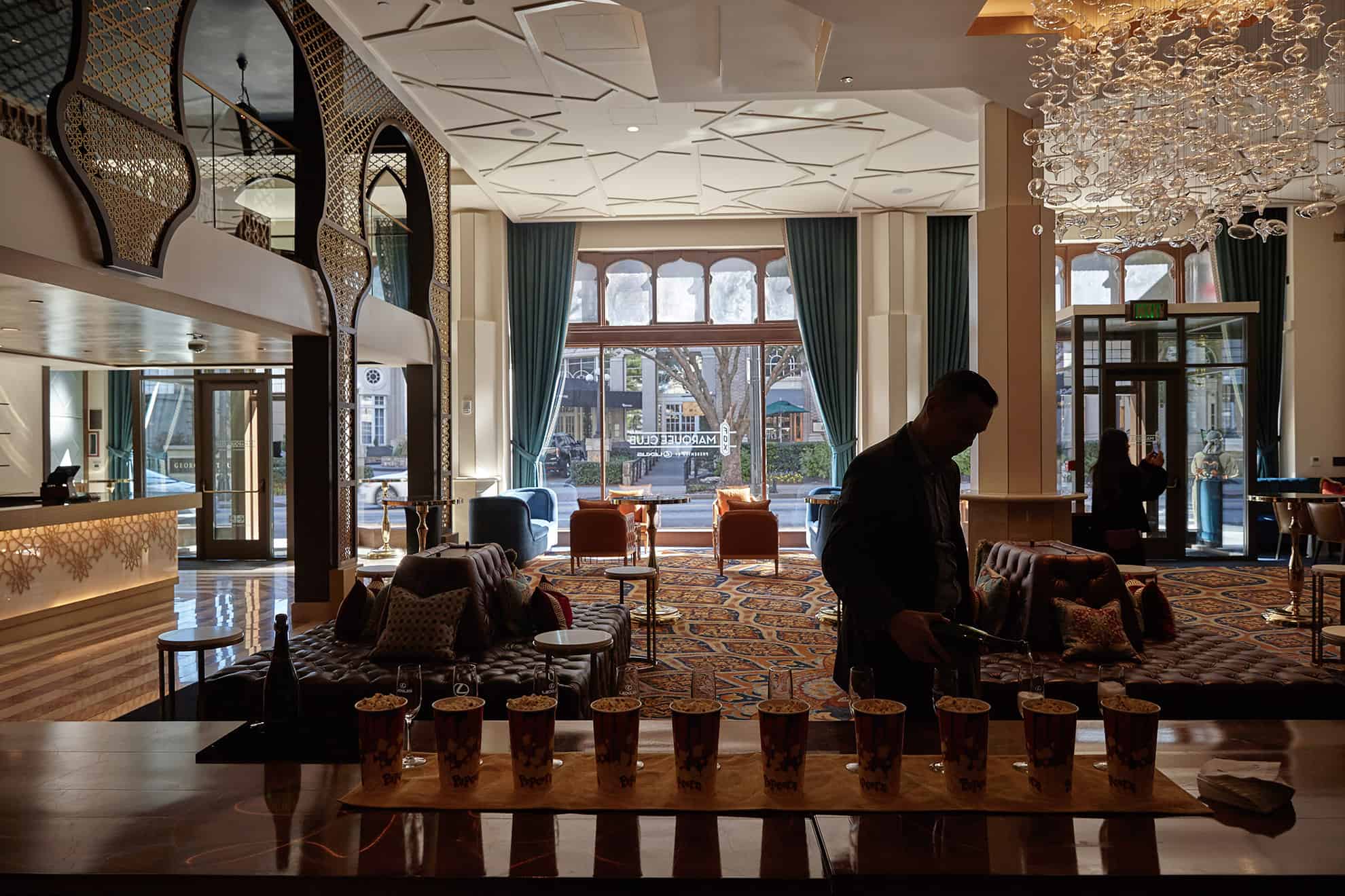 Hombre sirviendo champán en una mesa del lobby del hotel para dar la bienvenida a los huéspedes