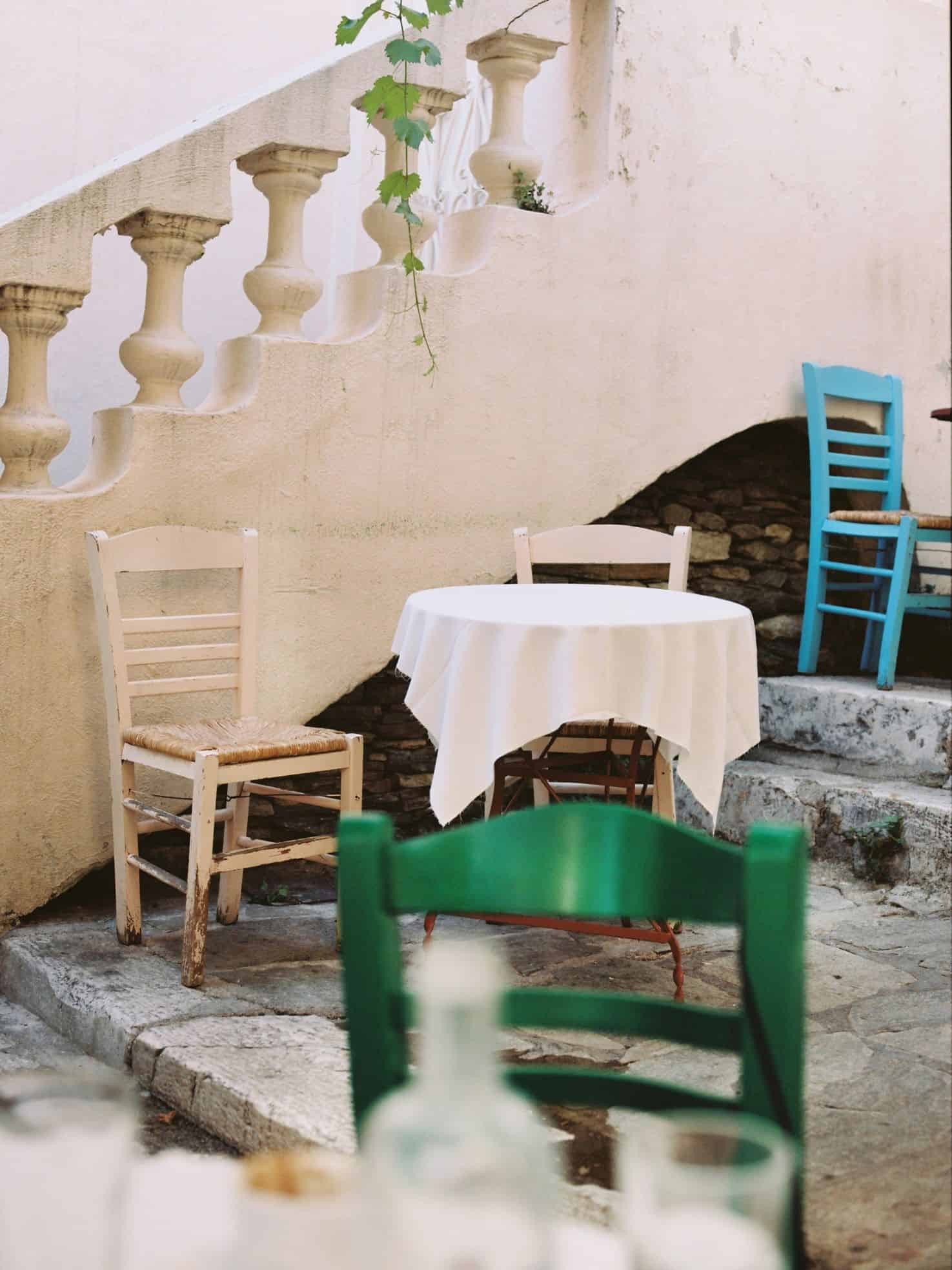 Quaint stone pathway with charming, mismatched sets of tables and chairs for dining