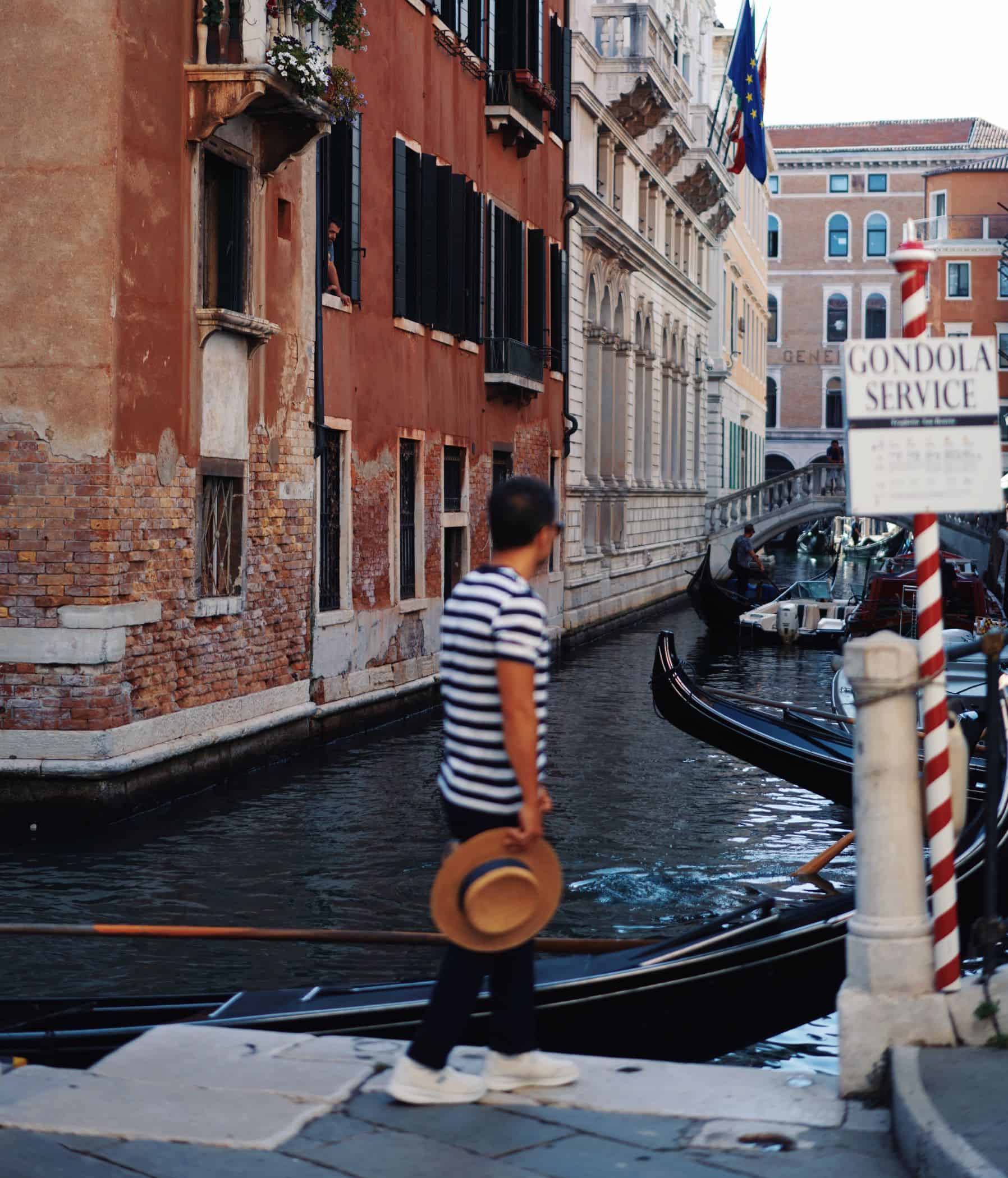 Man walking along the side of a canal