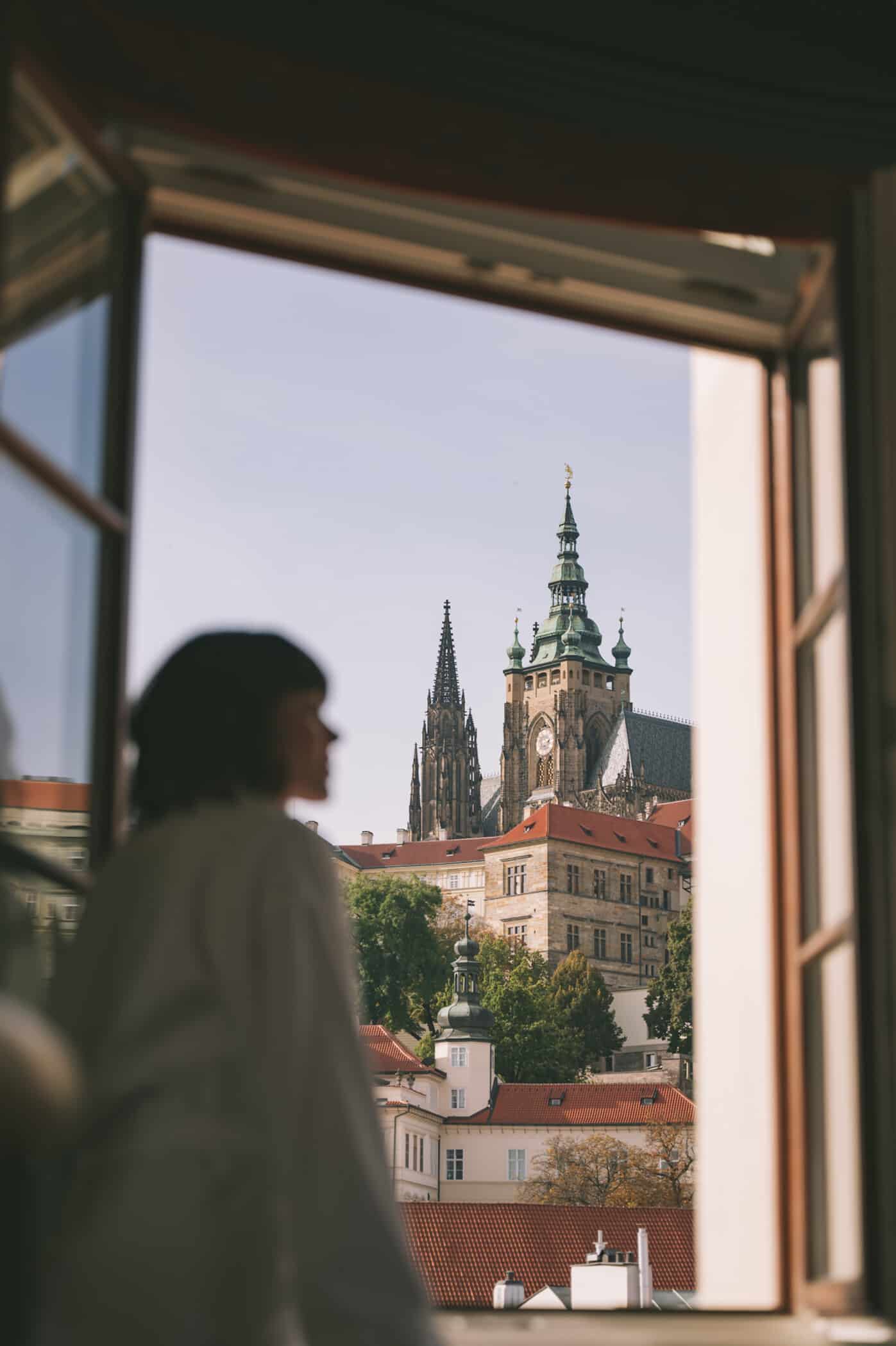 Profile of woman looking out a window towards a tall church
