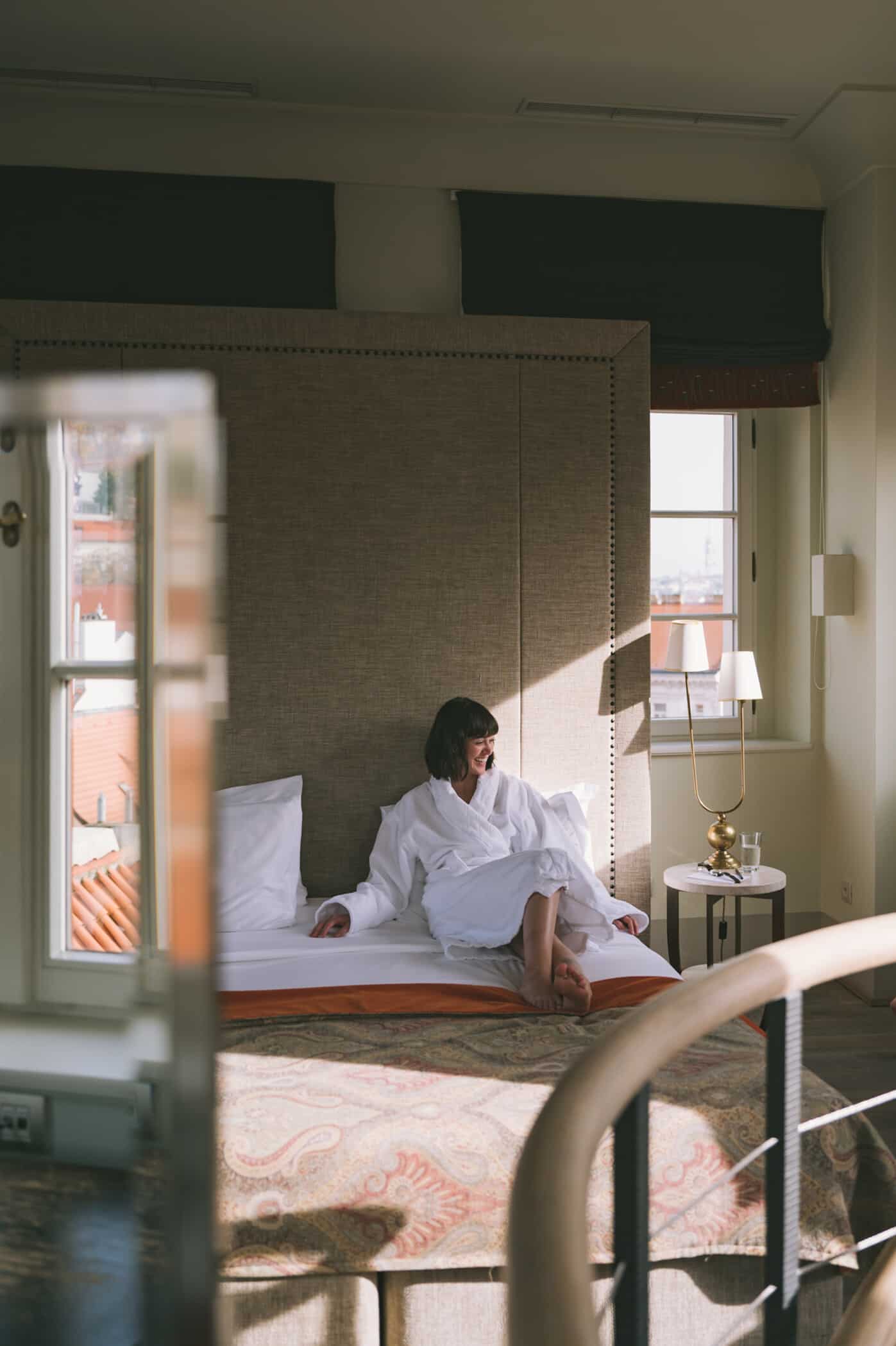 Woman in white robe relaxing on a bed