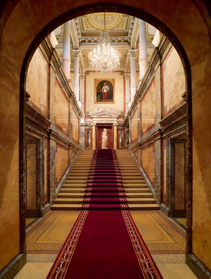 Royal Staircase with red carpet and chandelier