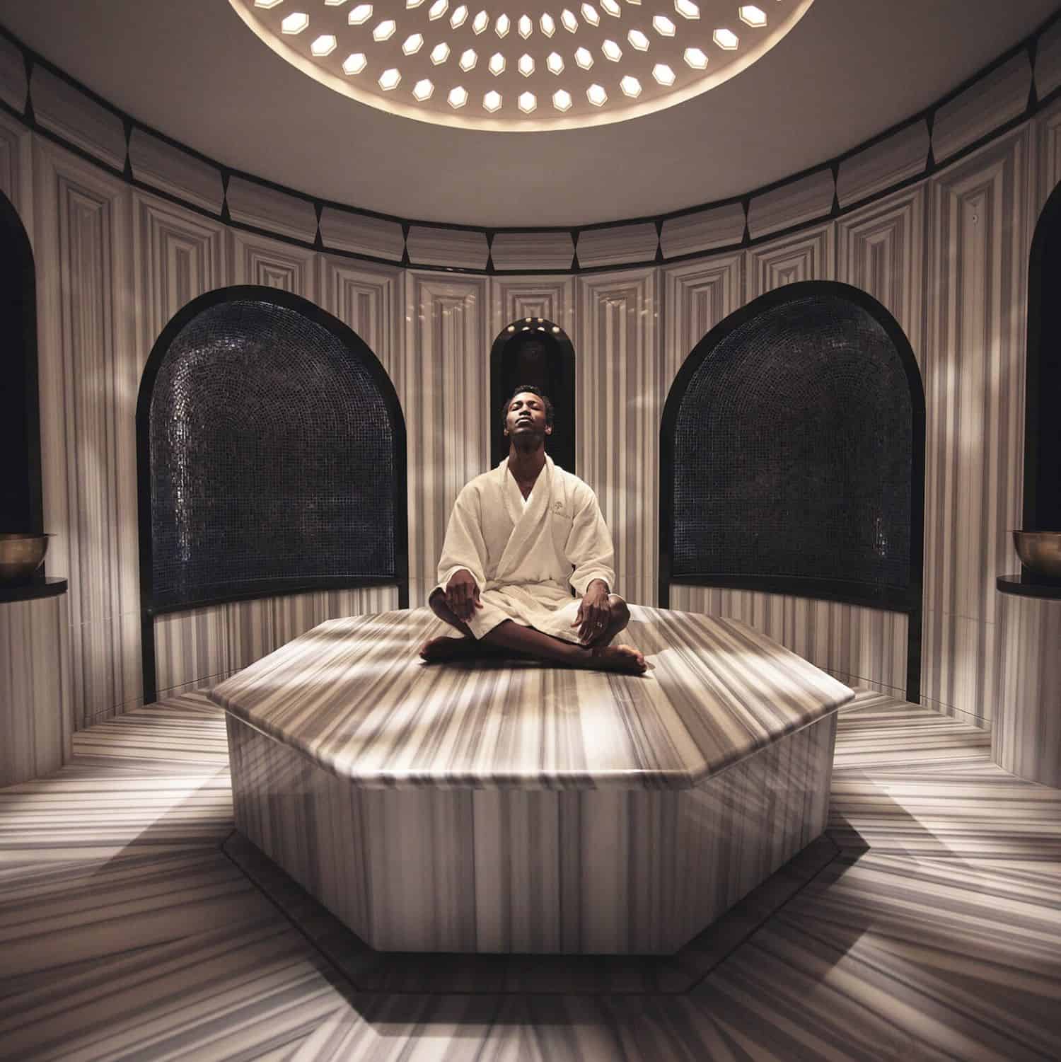 Man in robe meditating in spa