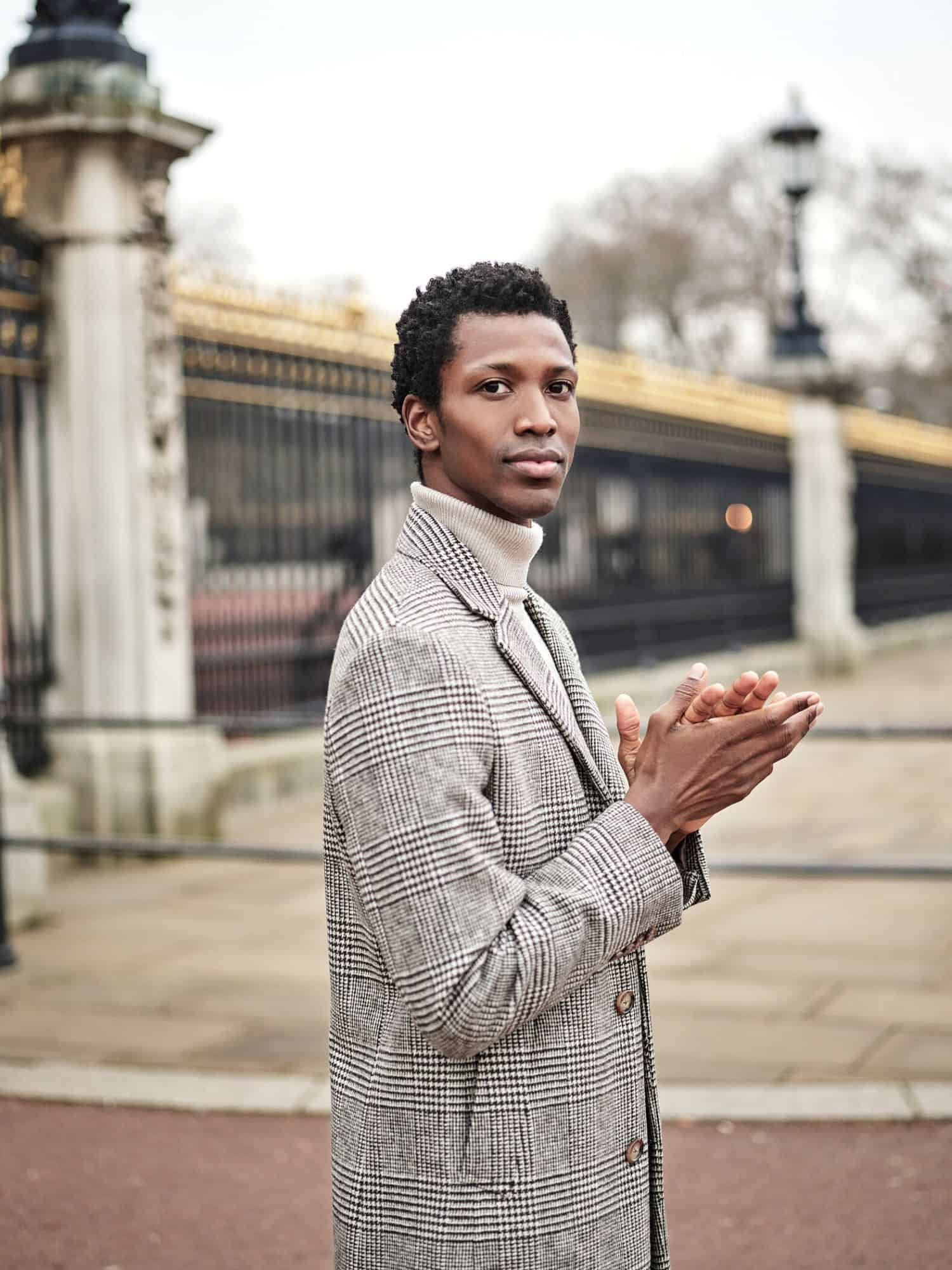 Man in stylish coat outside Buckingham Palace