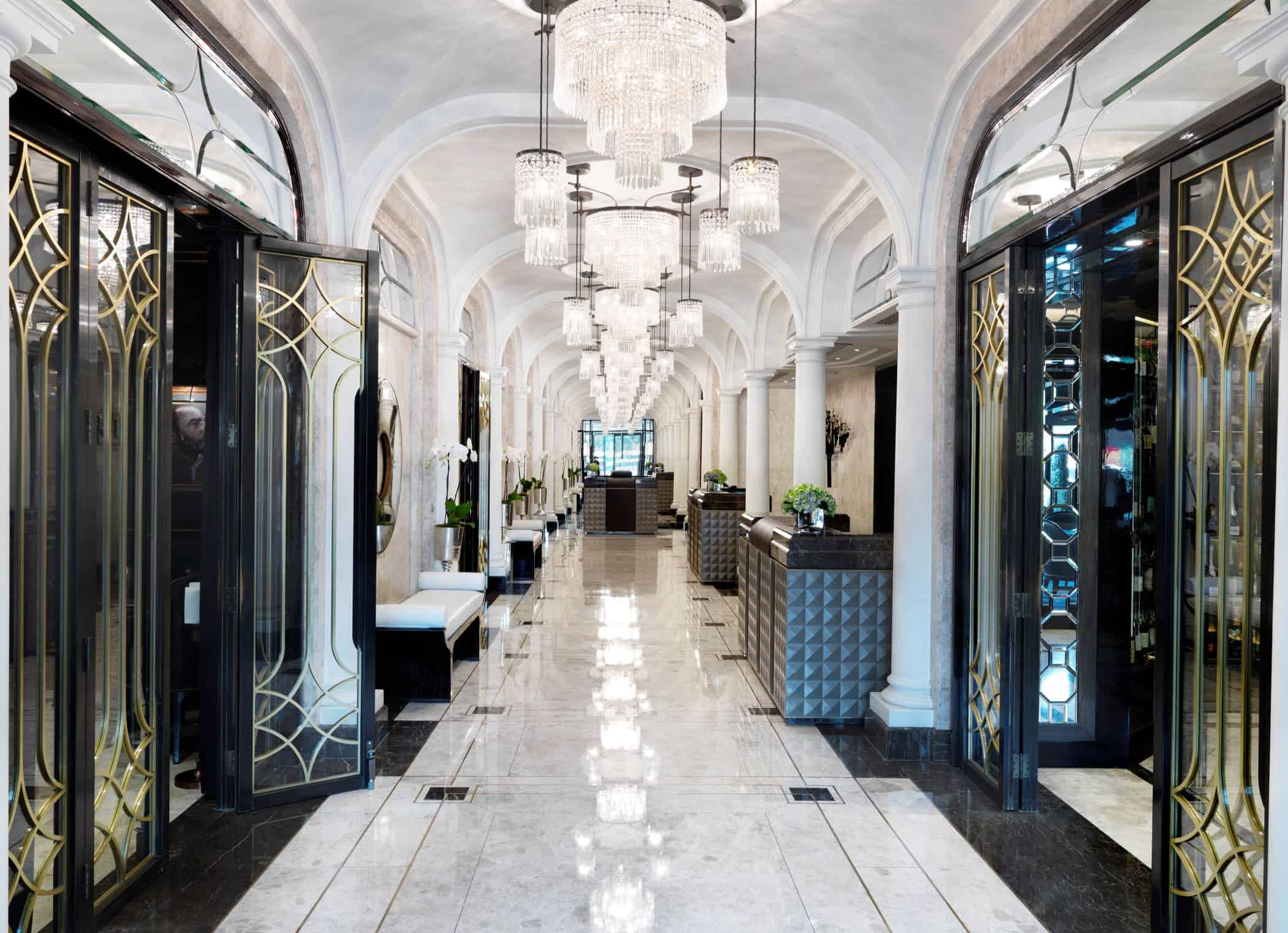 Upscale marble hallway with chandeliers and leather benches