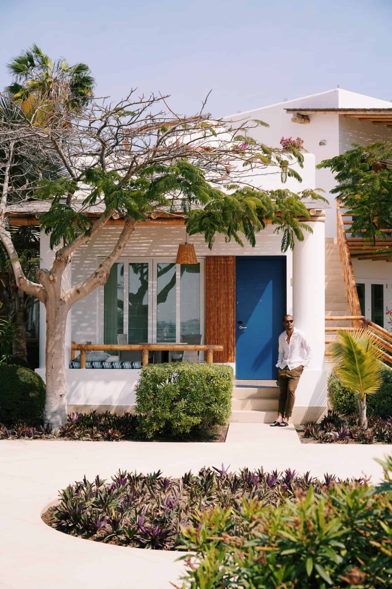 Man leaning against a pillar outside a home