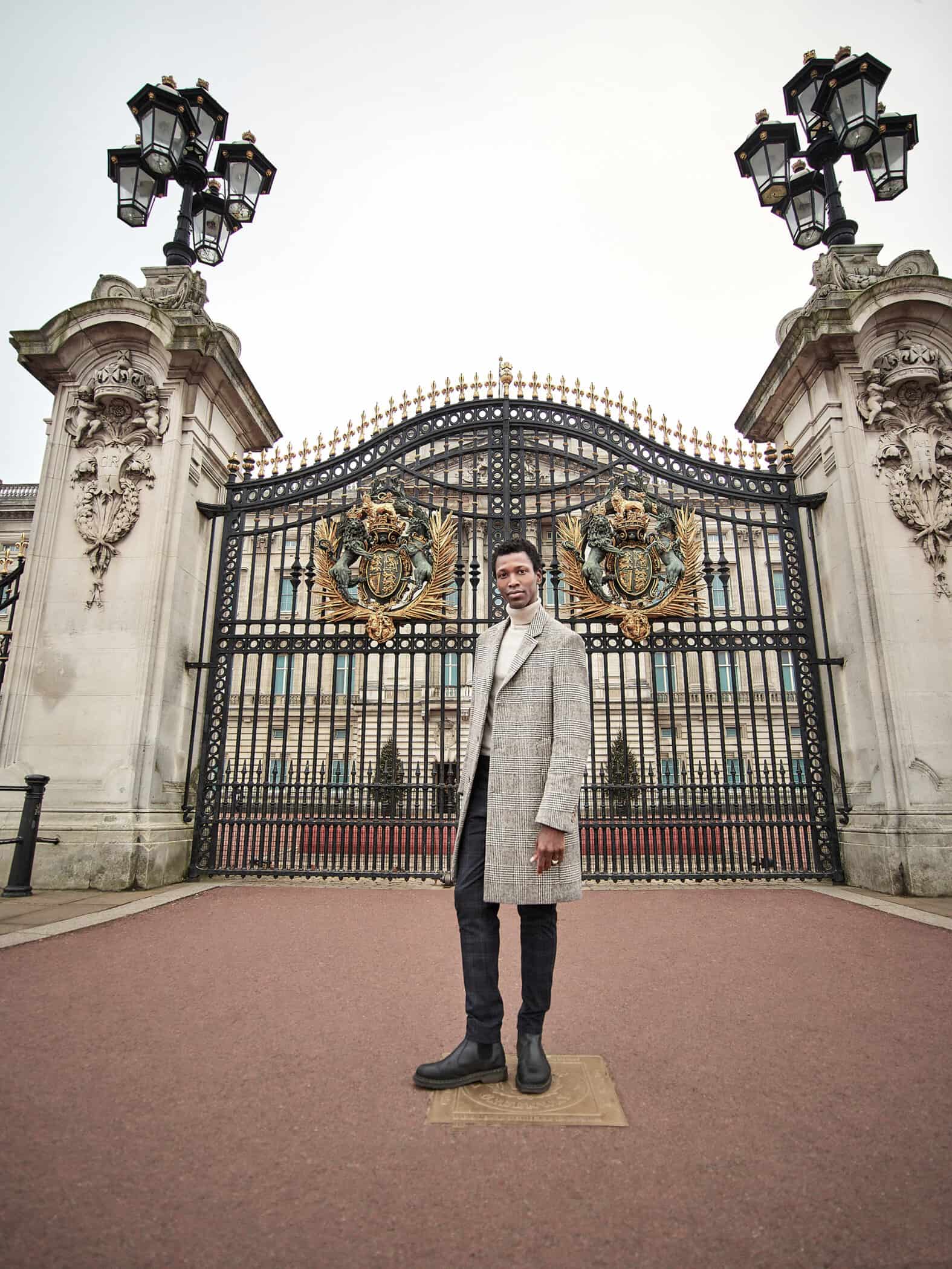 Man standing in front of Buckingham Palace Gates