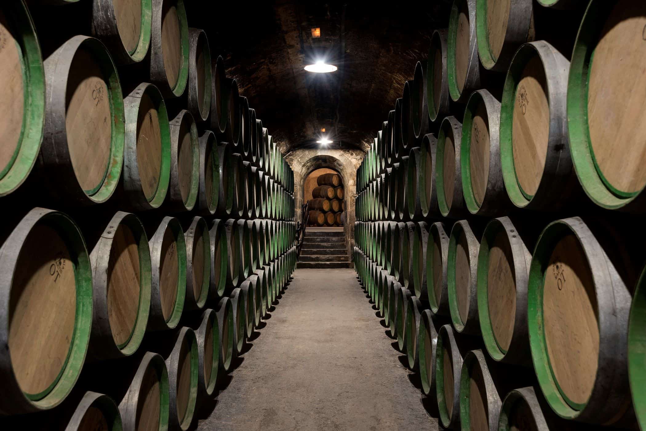Wine barrels stacked in rows on side