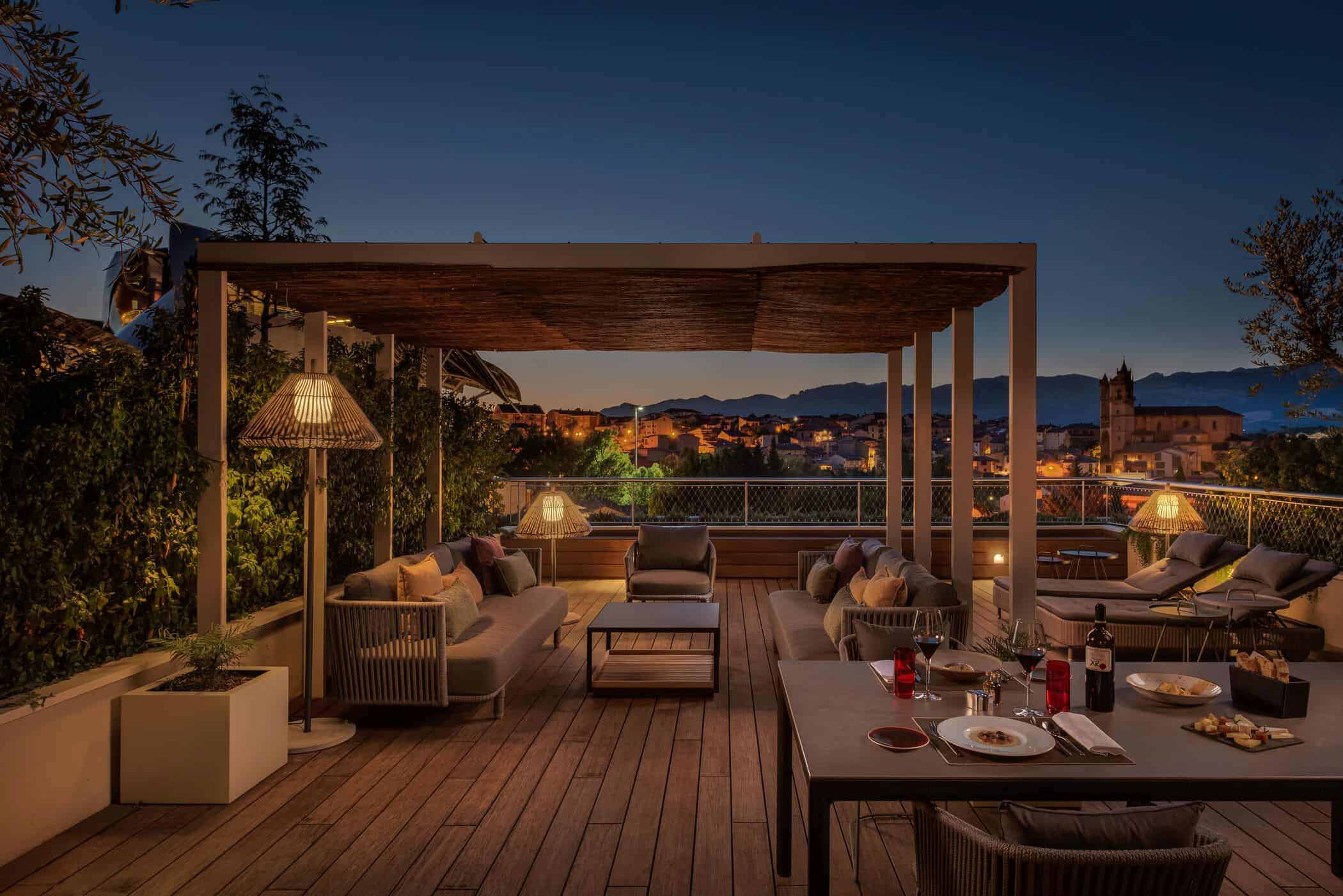 Outdoor patio with pergola and seating at night