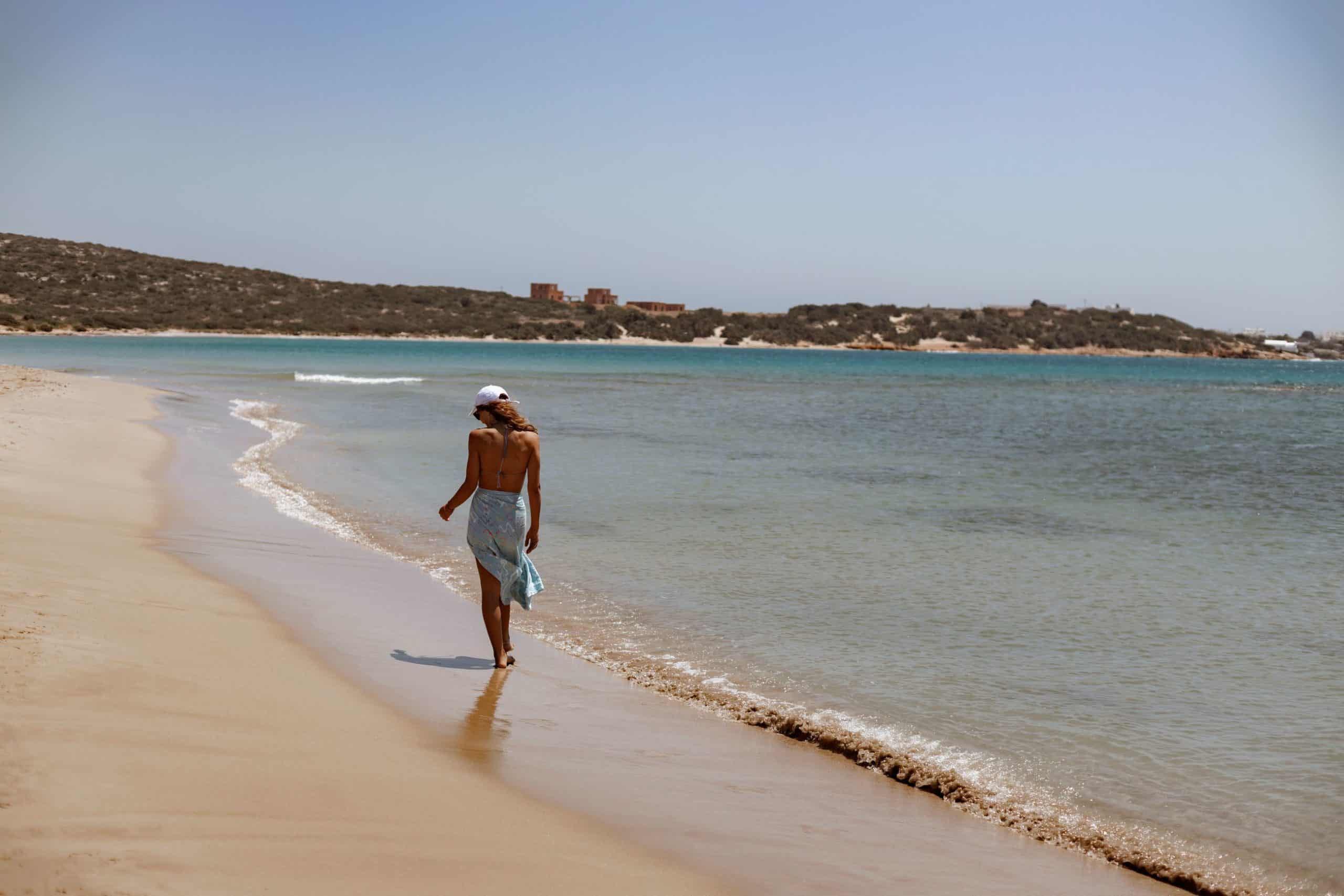 Woman walking away along the beach