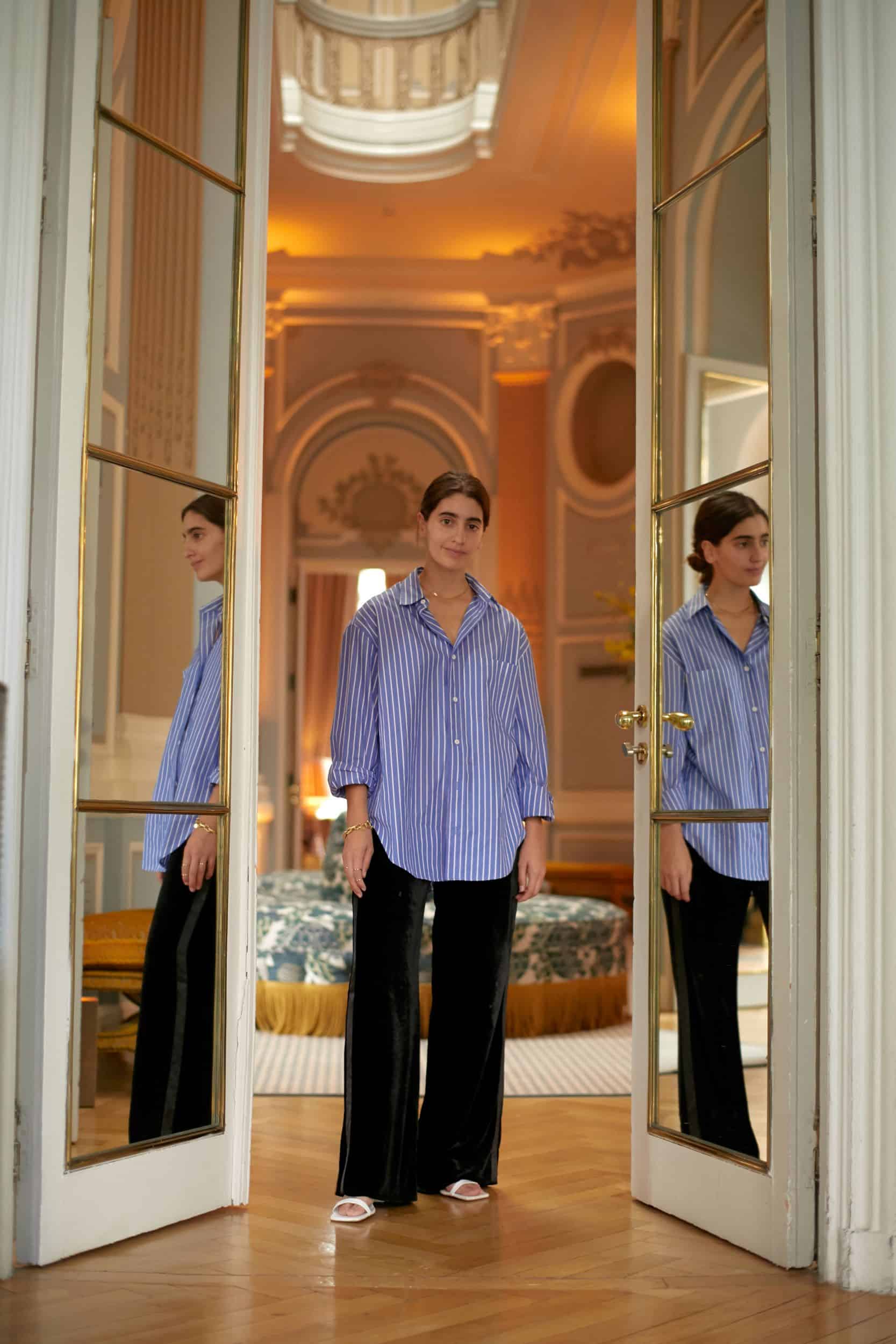 Woman standing with her reflection in glass on each side