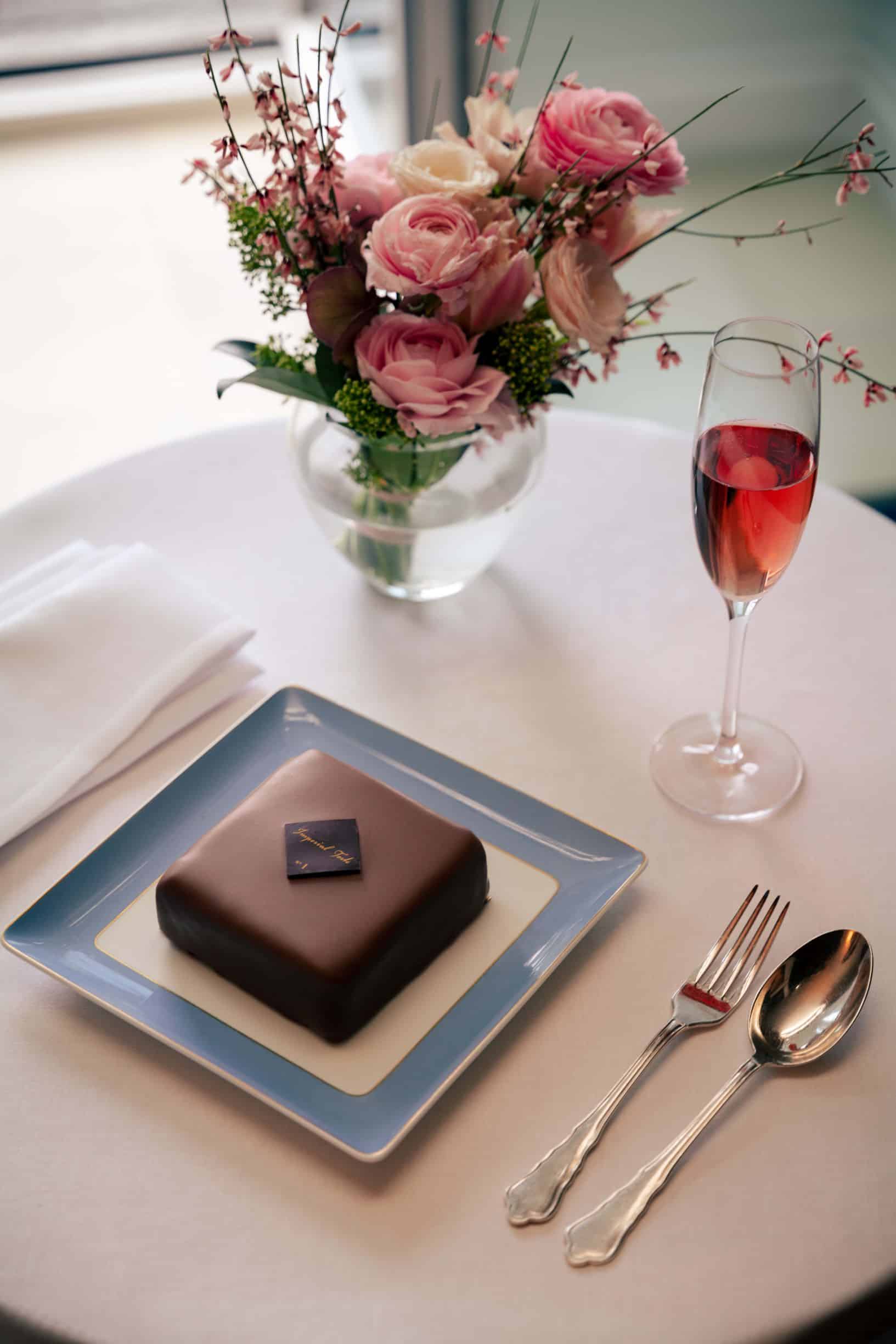 torte displayed on table with rosé and floral centerpiece