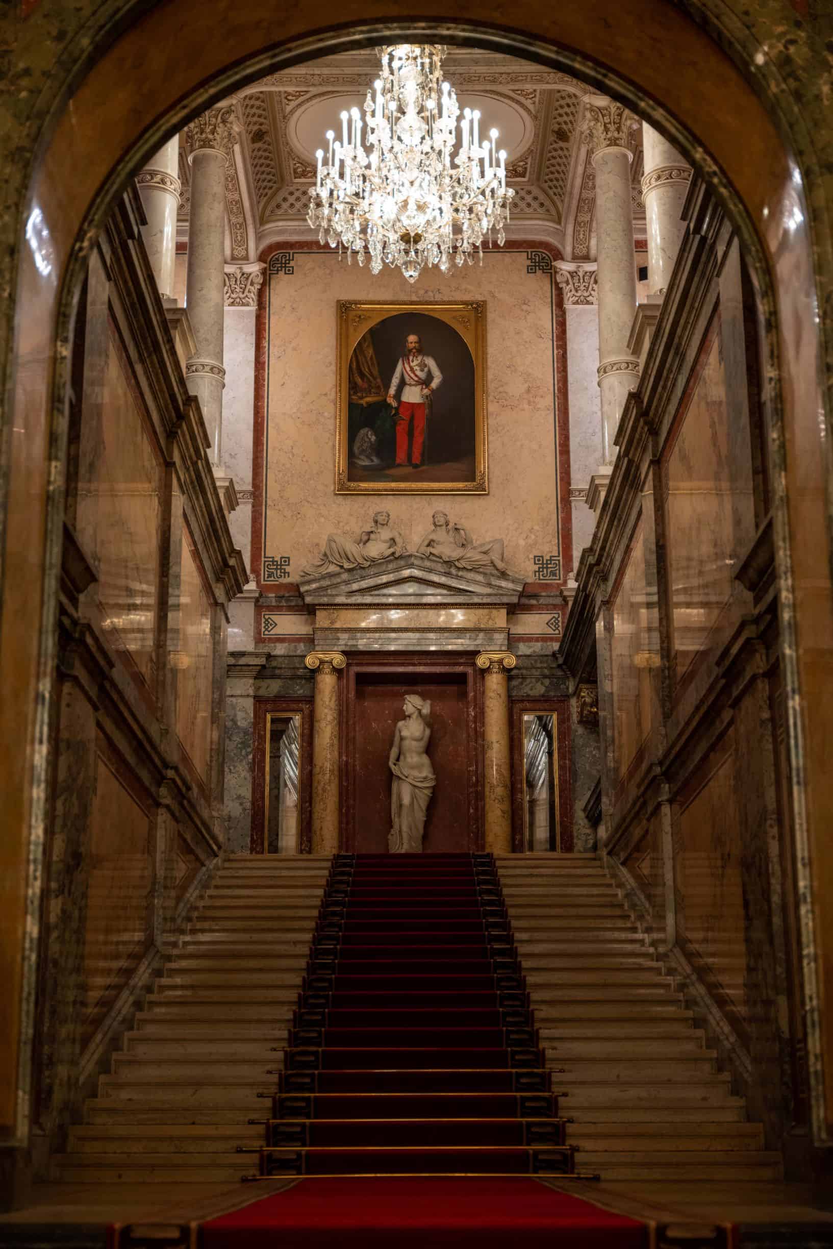 Staircase showcasing historic painting and statue