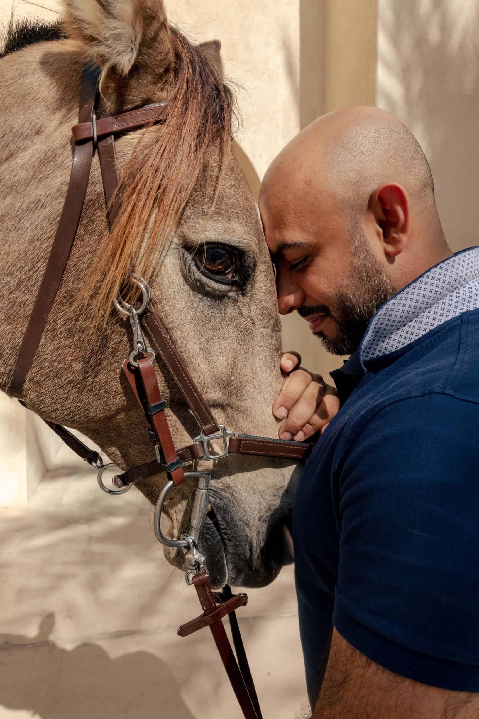 man petting horse