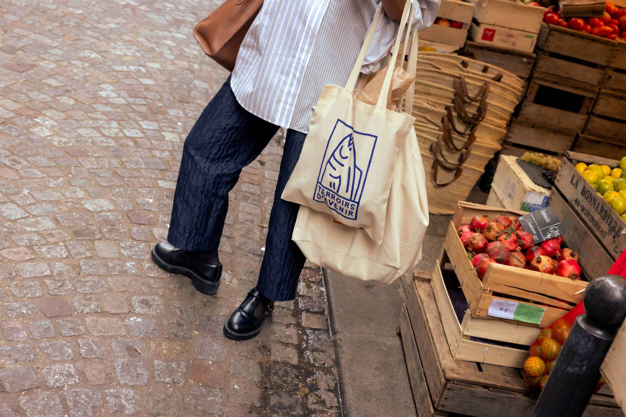 woman walking on street with 2 totes